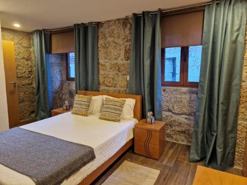 sypialnia z łóżkiem i 2 oknami w obiekcie Quinta da Casa dos Santos - Inside Gerês w mieście Geres