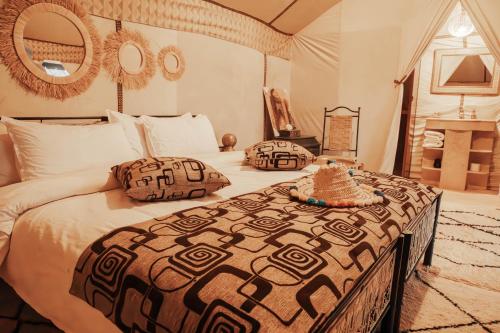 - une chambre avec un grand lit et des oreillers dans l'établissement Moonlight Desert Camp, à Merzouga