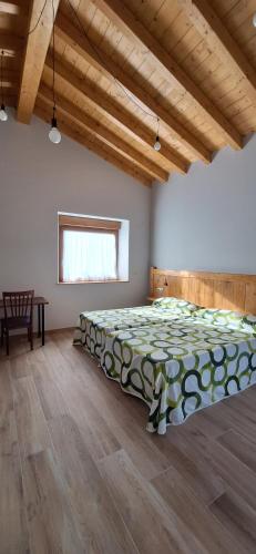 Casa Rural Launtzin Landetxea في Areatza: غرفة نوم بسرير كبير في غرفة ذات أرضيات خشبية