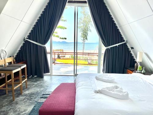 a bedroom with a bed with a view of the ocean at 7 Heaven camping Lanta in Krabi town