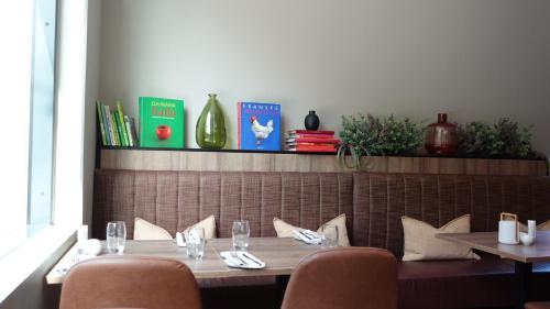 a dining room with two tables and chairs and books at Quality Hotel Fredrikstad in Fredrikstad