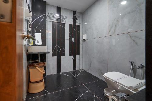 a bathroom with a white toilet and a sink at The Scenic Unity in Garudeshwar