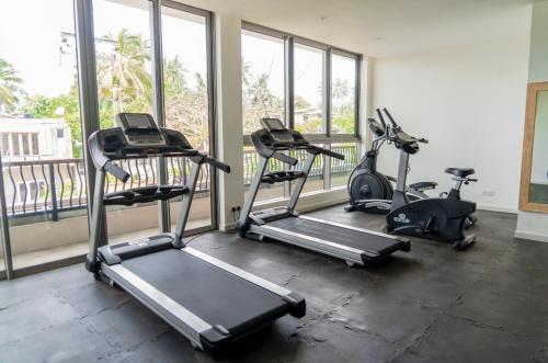 a gym with three treadmills and a row of windows at Oceanfront Condos Galle-Apartment L410 A in Galle