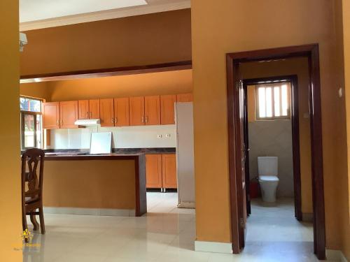 a kitchen with orange cabinets and a toilet at Pleasant Rusororo in Kigali