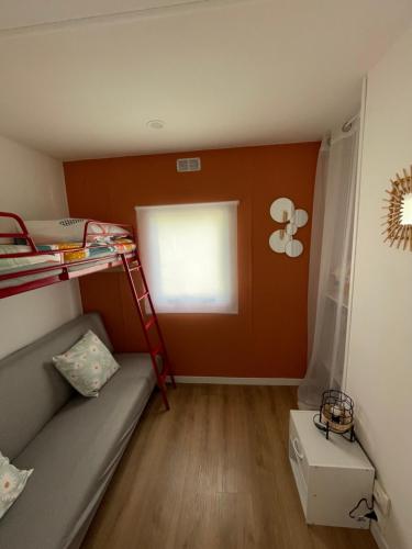 a small room with a bunk bed and a window at Camping des Acacias in Saint-Paulet-de-Caisson