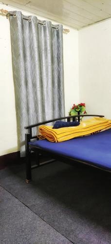 a bed with a yellow blanket on top of it at Mirik Homestay in Mirik