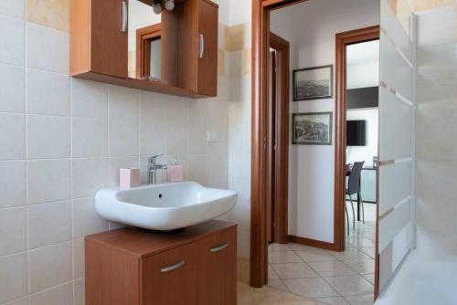 y baño con lavabo blanco y espejo. en Bella Ciao Airport Apartment, en Seriate