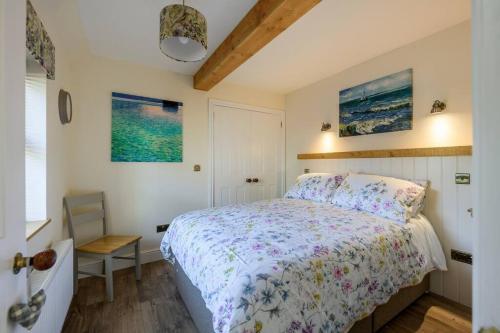 a bedroom with a bed with a floral bedspread at Country Cottage by St. Andrews in St Andrews