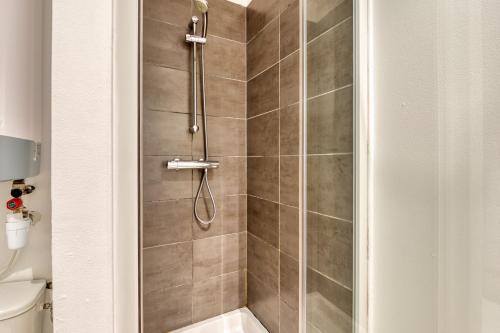 La salle de bains est pourvue d'une douche avec une porte en verre. dans l'établissement Le BlueArt, votre logement au cœur de Rouen, à Rouen