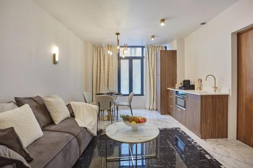 un salon et une cuisine avec un canapé et une table dans l'établissement Apart hotel Louvre museum by Studio prestige, à Paris