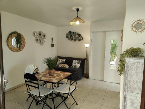 un salon avec une table, des chaises et un canapé dans l'établissement Studio 150 m de la plage Agosta, à Albitreccia