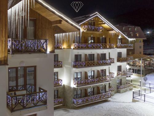 um edifício com varandas na neve à noite em Crystal Hotel & SPA em Bakuriani