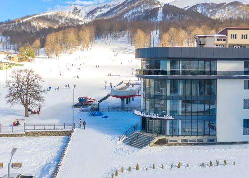 a ski lodge with people on the slopes in the snow at Crystal Hotel & SPA in Bakuriani