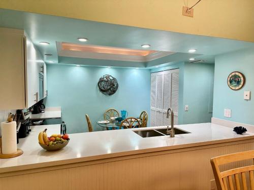 una cucina con pareti blu e un bancone con un cesto di frutta di Nautical Adventures in Paradise a Key West