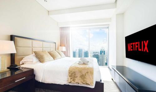 - une chambre avec un grand lit et une grande fenêtre dans l'établissement Luxury Address Res Dubai Marina 1BR a Frank&Frank, à Dubaï