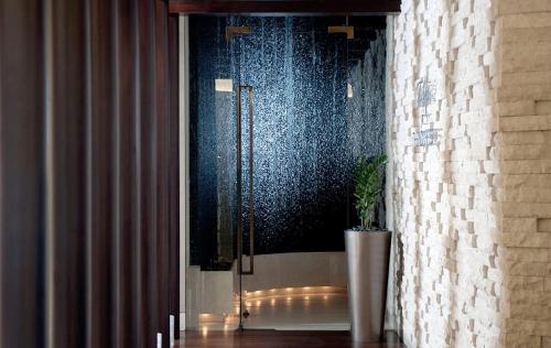 ドバイにあるLuxury Address Res Dubai Marina 1BR a Frank&Frankのガラスのドア付きのシャワーと植物