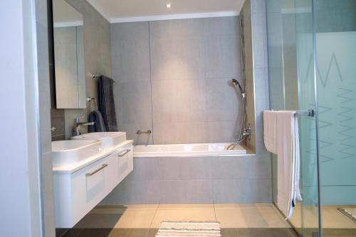 Jordan's Luxe Apartments في جوهانسبرغ: حمام مع حوض ومغسلة ودش