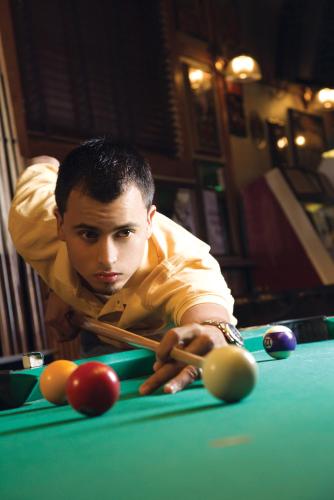 a man sitting at a pool table waiting for his ball at Dik Dik Hotel in Arusha