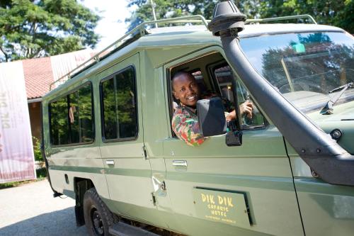 a man is sitting in a green van at Dik Dik Hotel in Arusha