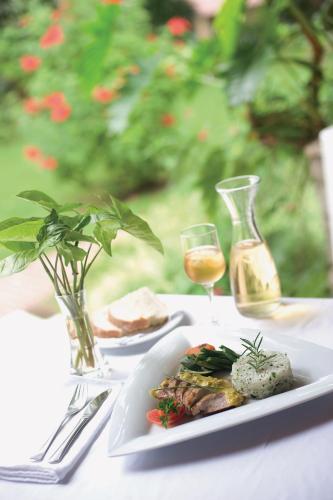 a plate of food and a glass of wine on a table at Dik Dik Hotel in Arusha
