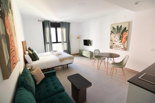 Habitación de hotel con cama, sofá y mesa en Letmalaga Gazules, en Málaga