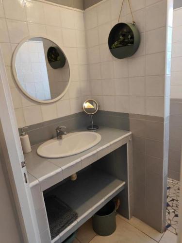 une salle de bain avec un lavabo et un miroir dans l'établissement Studio 150 m de la plage Agosta, à Albitreccia