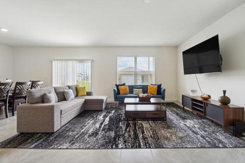 un salon avec un canapé et une télévision dans l'établissement Brand New 4-Bedroom House near Disney & Beaches!, à Port Sainte-Lucie