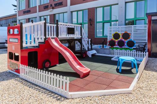 um parque infantil com um escorrega em frente a um edifício em Block 96 Apartments em Zlín