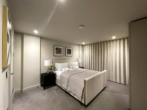 een slaapkamer met een groot wit bed en een raam bij 2BR Urban Vista Retreat CHCL F7 in Chigwell