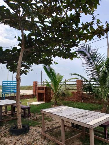a picnic table under a tree next to a beach at PULANG RESORT in Setiu