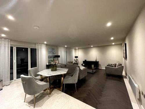 a living room with a couch and a table and chairs at 2BR Urban Vista Retreat CHCL F7 in Chigwell