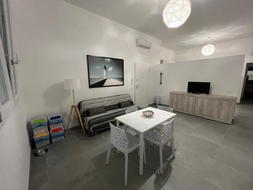 ein Wohnzimmer mit einem Tisch und einem Bett in der Unterkunft Fiume 21 apartment -3- Venturina Terme in Venturina Terme