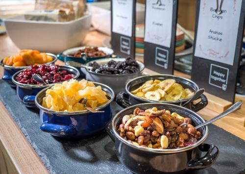 a table topped with bowls of different types of food at JUFA Hotel Altaussee in Altaussee