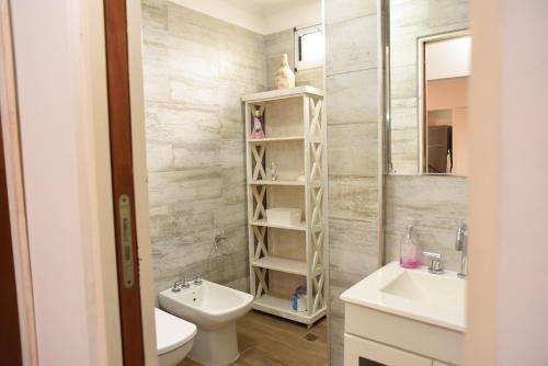 ein Badezimmer mit einem Waschbecken, einem WC und einem Spiegel in der Unterkunft Cozy House in San Nicolás de los Arroyos
