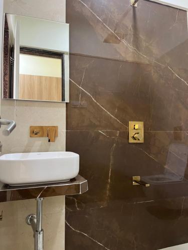 a bathroom with a sink and a mirror at Juhu Getaway with Rooftop Pad! in Mumbai
