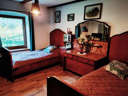 a bedroom with two beds and a dresser with a mirror at OAZA SPOKOJU NA FERMIE JELENI SLOW LIFE APARTAMENTy in Górowo Iławeckie