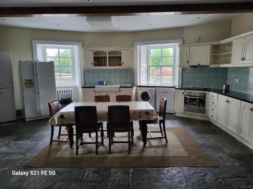 a kitchen with a table and chairs in it at Ballycurrin House in Galway