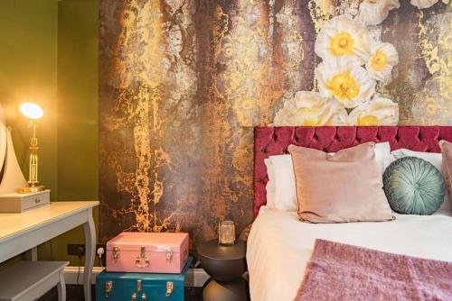 a bedroom with a bed with a floral wall at Worth Cottage - Perfect for families & friends in Worth