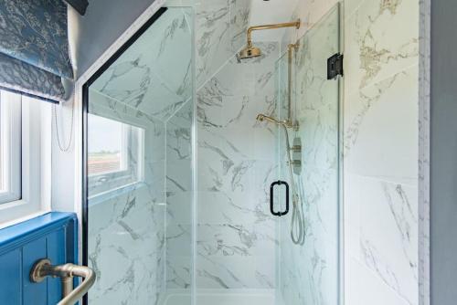 a bathroom with a shower with marble tiles at Worth Cottage - Perfect for families & friends in Worth
