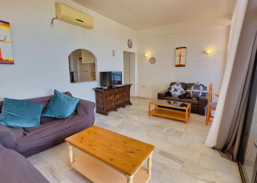 een woonkamer met een bank en een tafel bij Skol 935 - Cozy 2-Bedroom Apartment with Amazing Sea Views in Marbella