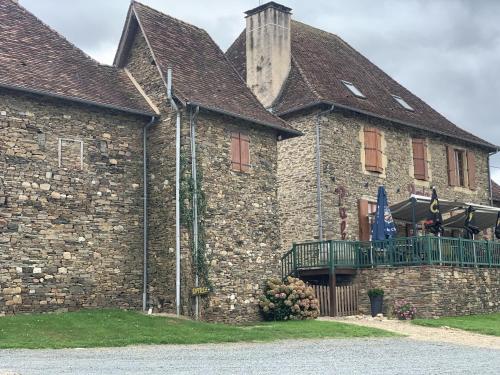 un gran edificio de ladrillo con balcón. en La Taverne du Boucher en Sarlande