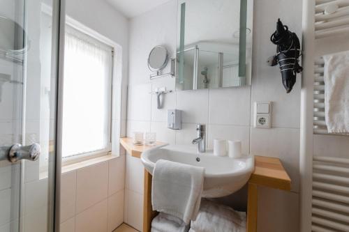 biała łazienka z umywalką i oknem w obiekcie Ferienhaus Panoramablick w mieście Niedersalwey