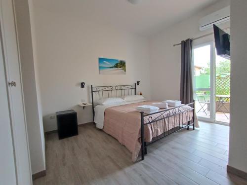 a bedroom with a bed and a large window at Costa di Sopra Affittacamere in Quartu SantʼElena