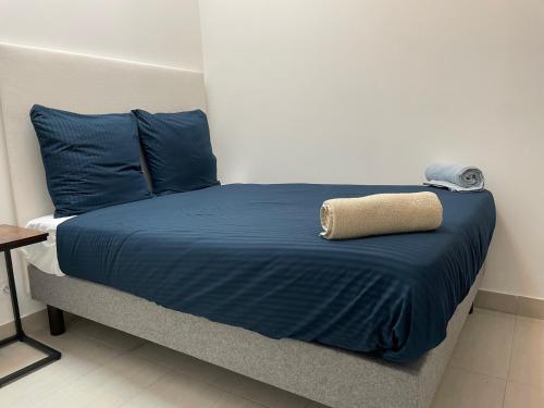 uma cama com um cobertor azul e almofadas azuis em T2 Proximité La Défense em Colombes