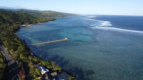 an aerial view of a beach with a train in the water at coral coast FIJI in Sigatoka