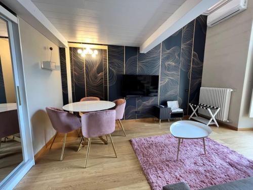 - un salon avec deux tables et des chaises ainsi qu'un tapis rose dans l'établissement B&B Torino Très Chic, à Turin
