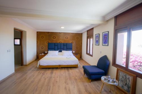 una camera con un grande letto e una testiera blu di Villa Tizra - guest house a AÃ¯n el Ksob