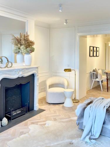 a living room with a fireplace and a chair at MEERBLICK-MAISONETTE Ostseebad Kühlungsborn in Kühlungsborn