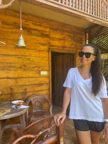 a woman standing in front of a wooden cabin at Sea View Resort in Kallady