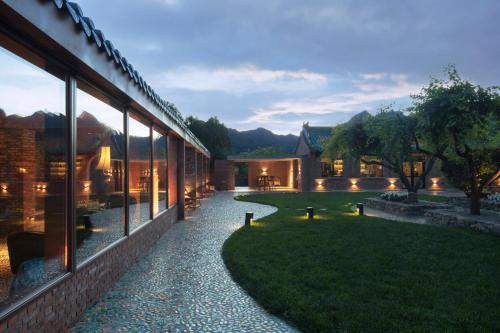 a building with a walkway next to a yard at Brickyard Retreat at Mutianyu Great Wall Adjoin to Mutianyu Great Wall - Room with the View of Great Wall - Chinese massage experience - Vehicle Shuttle Service - International Catering - SPA& Nail Beauty Facilities in Huairou